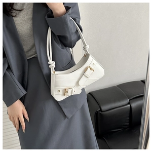 Gros plan d'un sac baguette blanc minimaliste avec boucles en métal et bandoulière nouée