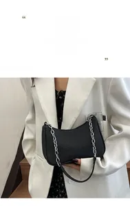 Detail of black crescent shoulder bag with silver chain strap and twill texture material