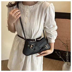 Close-up of black matte faux leather shoulder bag with punk style metal buckle straps