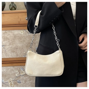 Close-up of cream shoulder bag with woven wavy texture and silver chain strap