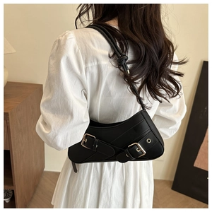 Détail du sac sous l'aisselle en similicuir noir avec boucles et sangle à nœuds
