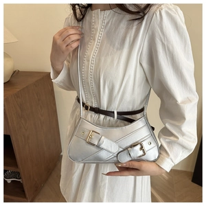 Détail du sac à épaule argenté métallisé avec boucles style biker et forme croissant