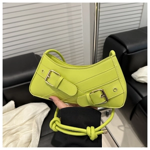 Détail du sac bandoulière en cuir PU vert fluo avec boucles métalliques et bandoulière nouée