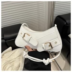 Détail du sac asymétrique blanc avec poignée nouée et brides à boucles dorées