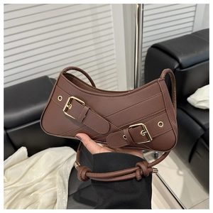 Détail du sac sous le bras en cuir marron foncé avec forme courbe et boucles