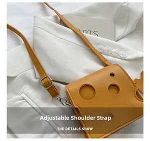Detail showing the adjustable leather shoulder strap on a yellow cheese-shaped crossbody bag