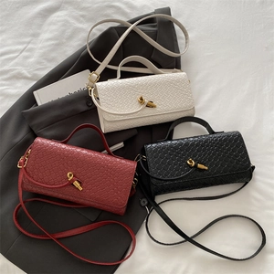 Woven leather crossbody accordion bags in white, red, and black with gold metal clasps