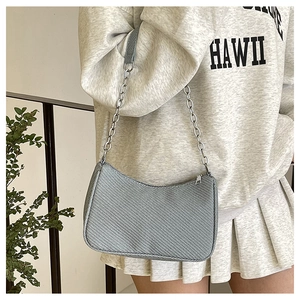 Chic grey-blue baguette bag with silver metal chain strap shown in a modern interior setting