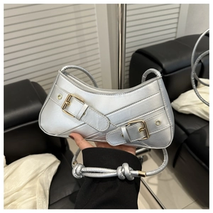 Détail du sac sous le bras en argent métallisé avec brides et poignée nouée chic