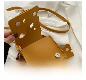 Detail showing the internal magnetic closure and cheese-shaped hole on the yellow crossbody bag