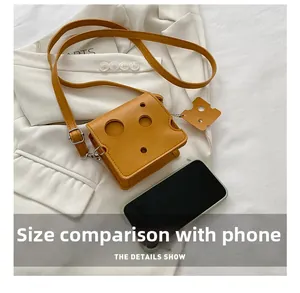 Detailed view of the yellow cheese crossbody bag showing its compact size next to a phone