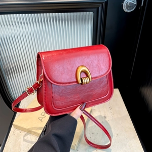 Elegant red vintage crossbody bag with glossy cracked texture and golden buckle