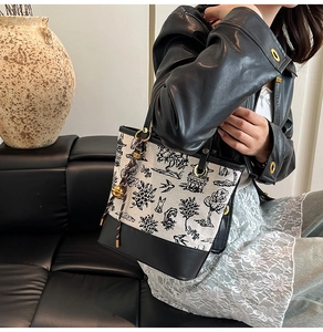 Detail of Toile de Jouy canvas bucket bag with retro pattern and black leather trim