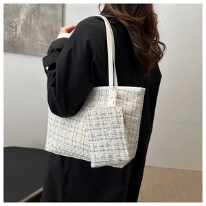 Detail of white tweed tote bag with gold thread texture and matching small pouch