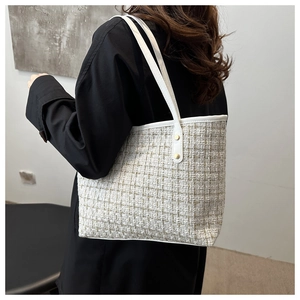 Modella che indossa una borsa tote in tweed bianco e oro con finiture in pelle
