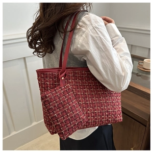 Dettaglio della borsa tote in tweed rosso con pochette coordinata indossata in un interno