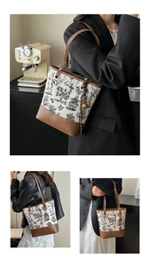 Detail view of large floral print tote bag with brown leather handles and bell charm accessory