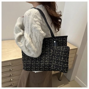 Detail of tweed tote bag with matching pouch and black leather shoulder strap on a model
