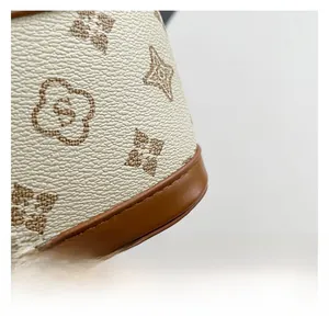 Detailed close-up of cream pebble grain fabric with vintage brown floral monogram print