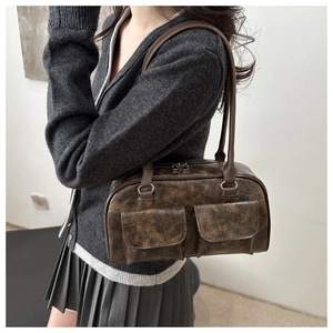 Dettaglio della borsa tote vintage in pelle marrone con due tasche frontali con patta