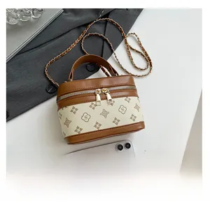 Detail of mini vintage box bag with floral print, leather trim, and chain strap next to a suit