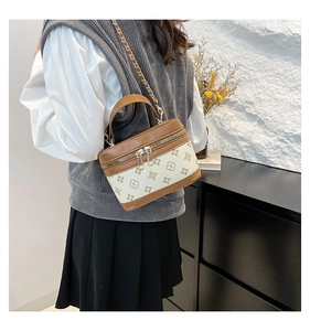 Detail view of the elegant printed vintage box bag worn as a shoulder bag by the model