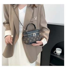 Brown vintage monogram vanity bag with gold chain strap worn with a beige blazer