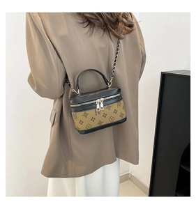 Detailed side view of a monogram canvas box bag with leather trim on model