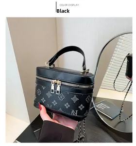 Close-up of black PU leather vanity bag with monogram pattern and gold chain strap
