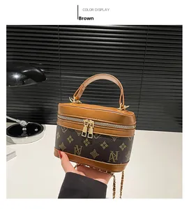 Detail of a mini retro box bag with vintage monogram pattern and gold chain strap