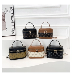 Detailed row of five luxury monogram vanity bags with metal chain straps and top handles