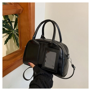 Détail du sac Boston noir brillant avec poignées rondes et fente pour carte transparente