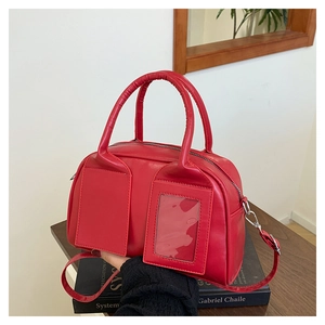 Détail du sac Boston rouge avec doubles poignées et poche à fente pour carte transparente