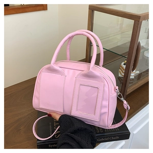 Vue détaillée du sac Boston rose avec doubles poignées et fente pour carte transparente