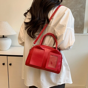 Sac Boston rouge chic avec fente pour carte présenté dans un décor intérieur élégant