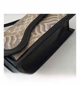 Detail of wave pattern jacquard fabric and clean stitching on a crossbody bag side
