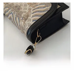 Close-up of jacquard fabric texture and golden hardware hook on Chinese style crossbody bag