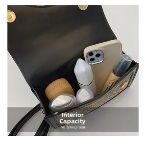 Macro view of black leather crossbody bag interior showing storage capacity and magnetic clasp