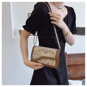 Detailed view of a vintage Chinese-style crossbody bag with wave pattern fabric and leather trim
