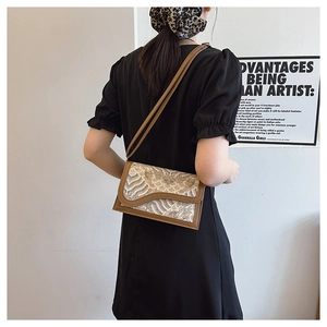 Detailed view of embroidery pattern on retro crossbody bag with leather strap