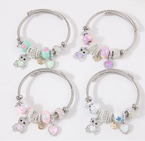 Detail van kralenarmbanden met fonkelende beerbedels en hartvormige hangers