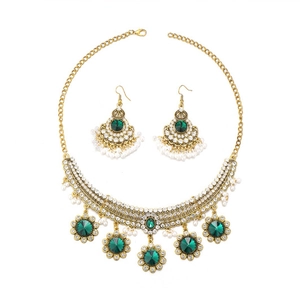 Détail d'une parure vintage bohème avec cristaux verts et perles blanches