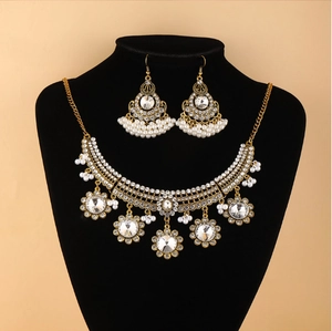 Détail de la parure collier fleurs dorées de style bohème avec strass sur présentoir