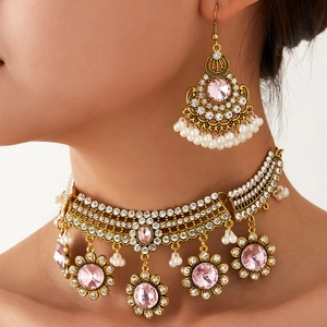 Parure de bijoux bohème dorée avec cristaux roses, perles et collier à fleurs sur mannequin