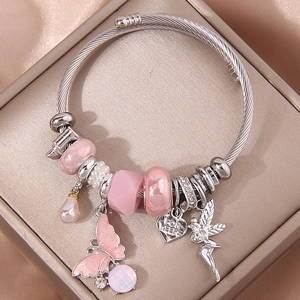 Silver twisted cable bangle with pink butterfly, engraved heart, and fairy charms