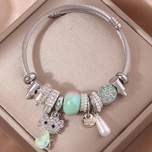 Silver twisted bangle with sparkling cat charm and handmade tag on satin display