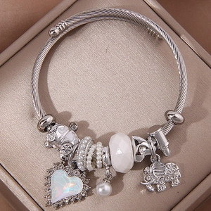 Silbernes Armband mit Elefanten- und Herzanhänger sowie Perlen auf Satin-Schmuckkästchen