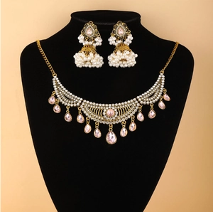 Détail d'une parure ethnique avec pierres roses et perles blanches sur un buste noir