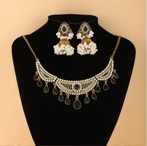 Détail d'un ensemble de bijoux orientaux vintage avec pierres noires et perles sur présentoir