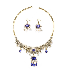 Détails d'une parure de bijoux vintage avec pierres bleues et perles blanches